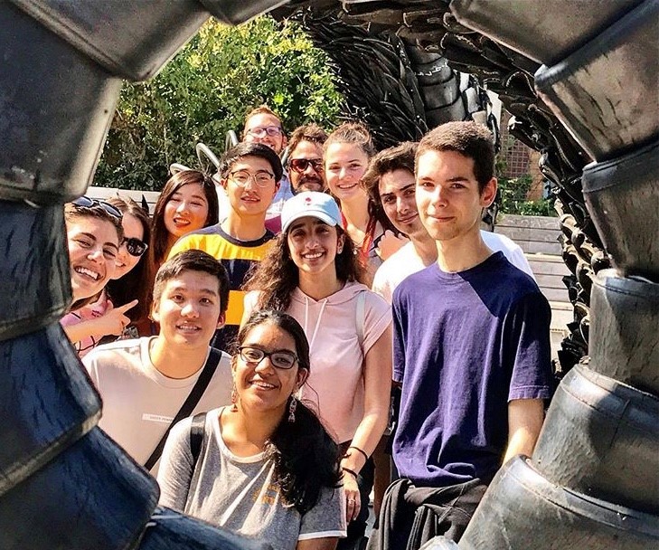 Group of diverse, international Loyola University Chicago students, from the perspective inside a giant tire, likely at a park.